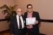 Dr. Nagib Callaos, General Chair, giving Dr. Julio Francisco Dantas de Rezende the best paper award certificate of the session "Inter-Disciplinary Communication ." The title of the awarded paper is "Creating the Economy of Virtuality: Systemic Aspects and Educational Considerations."